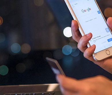 Laptop och mobiltelefon som visar Googles startsida