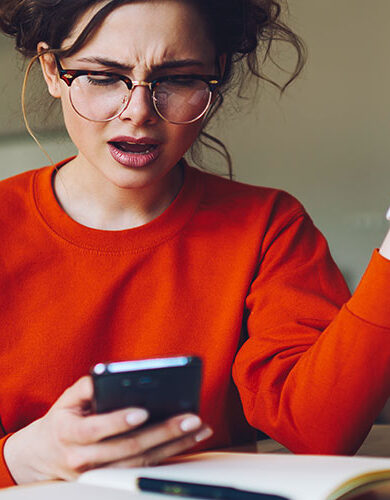 Besviken och irriterad kvinna med mobiltelefon