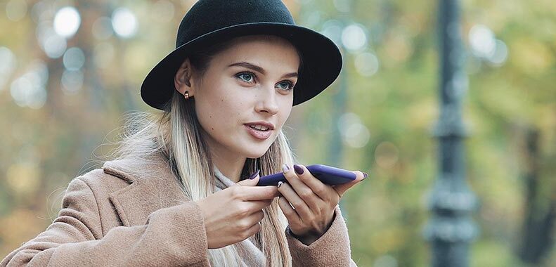 Kvinna i park använder voice search