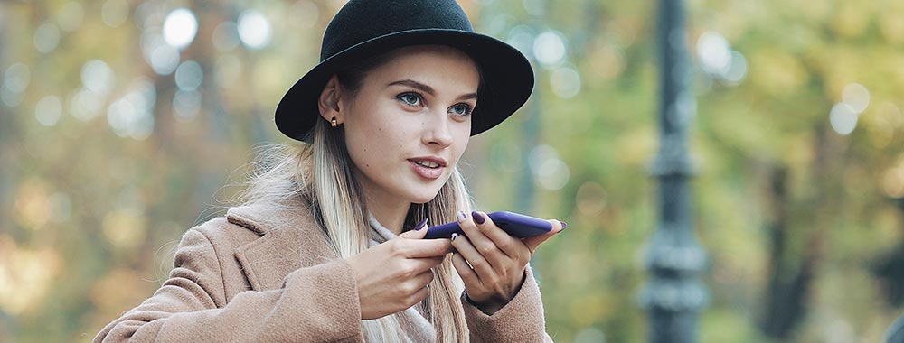 Kvinna i park använder voice search